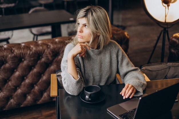 Donna d'affari che lavora al computer in un bar