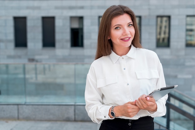 Donna d&#39;affari con un tablet in strada