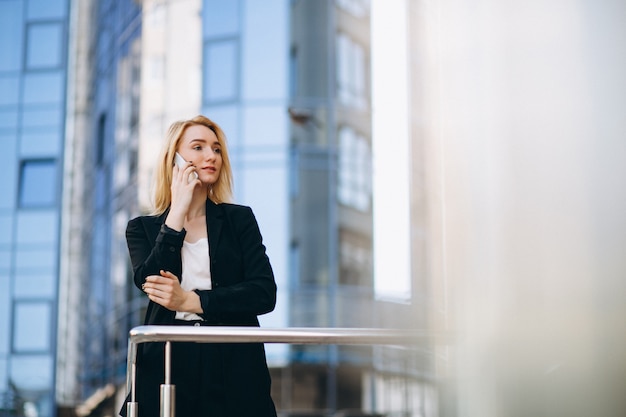 Donna d&#39;affari dal grattacielo utilizzando il telefono