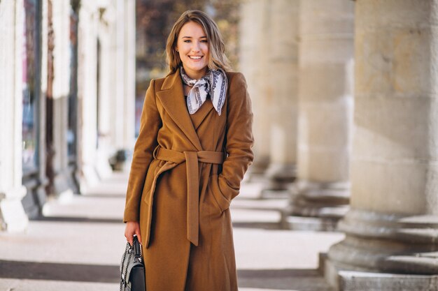 Donna d&#39;affari felice in cappotto in strada