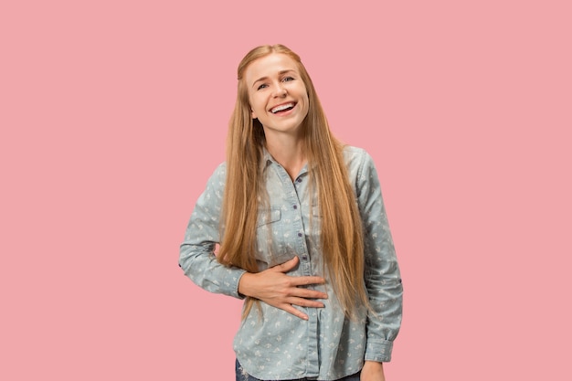 Donna d'affari felice in piedi e sorridente isolato su sfondo rosa studio. Bellissimo ritratto femminile a mezzo busto. Giovane donna emotiva.