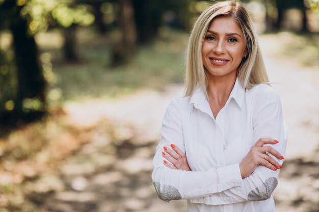 Donna d'affari in camicia bianca nel parco