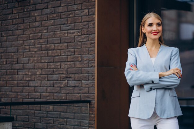 Donna d'affari in giacca blu vicino al centro dell'ufficio