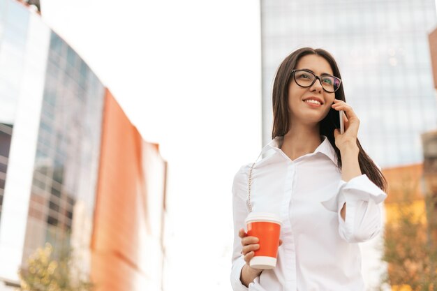 Donna d'affari sorridente che parla al telefono