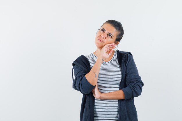 Donna dai capelli scuri che copre il viso con la camicia