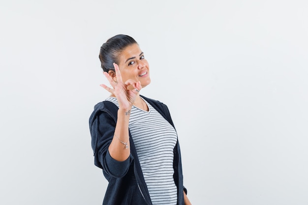 Donna dai capelli scuri che mostra gesto giusto in camicia