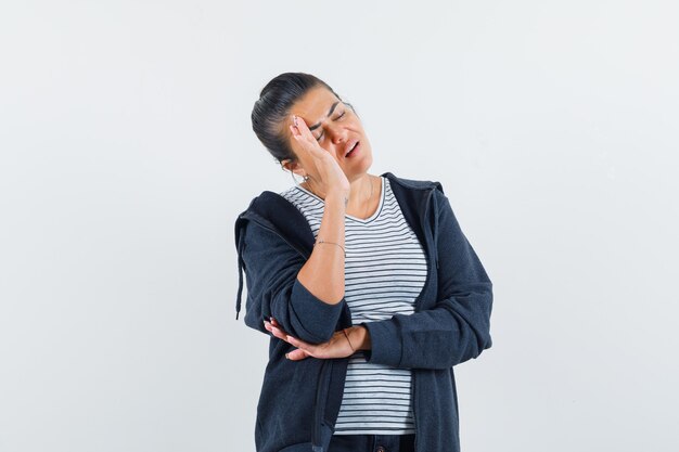 Donna dai capelli scuri che tiene la mano dietro la testa in camicia