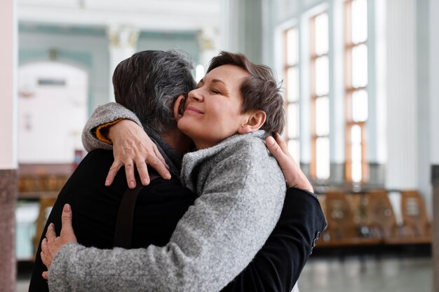 Donna del colpo medio che abbraccia l'uomo