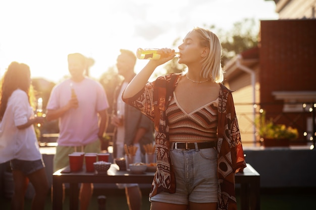 Donna del colpo medio che beve birra alla festa