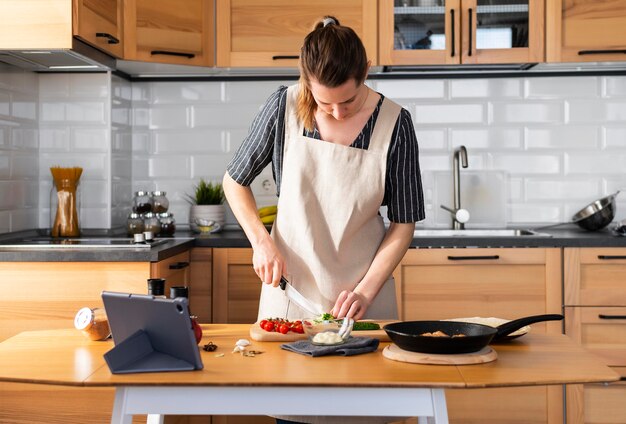 Donna del colpo medio che cucina a casa