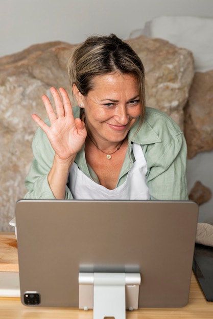 Donna del colpo medio che fluttua al tablet