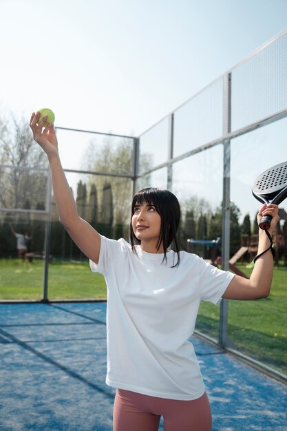 Donna del colpo medio che gioca a paddle tennis