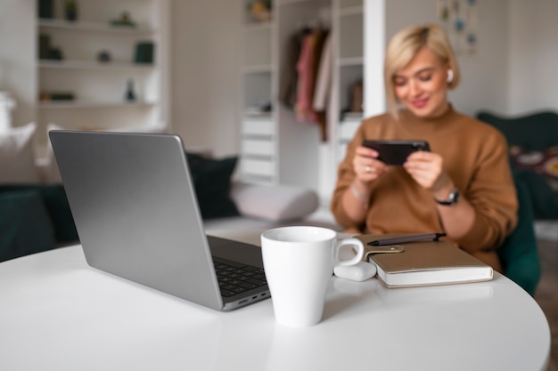 Donna del colpo medio che gioca con il suo telefono