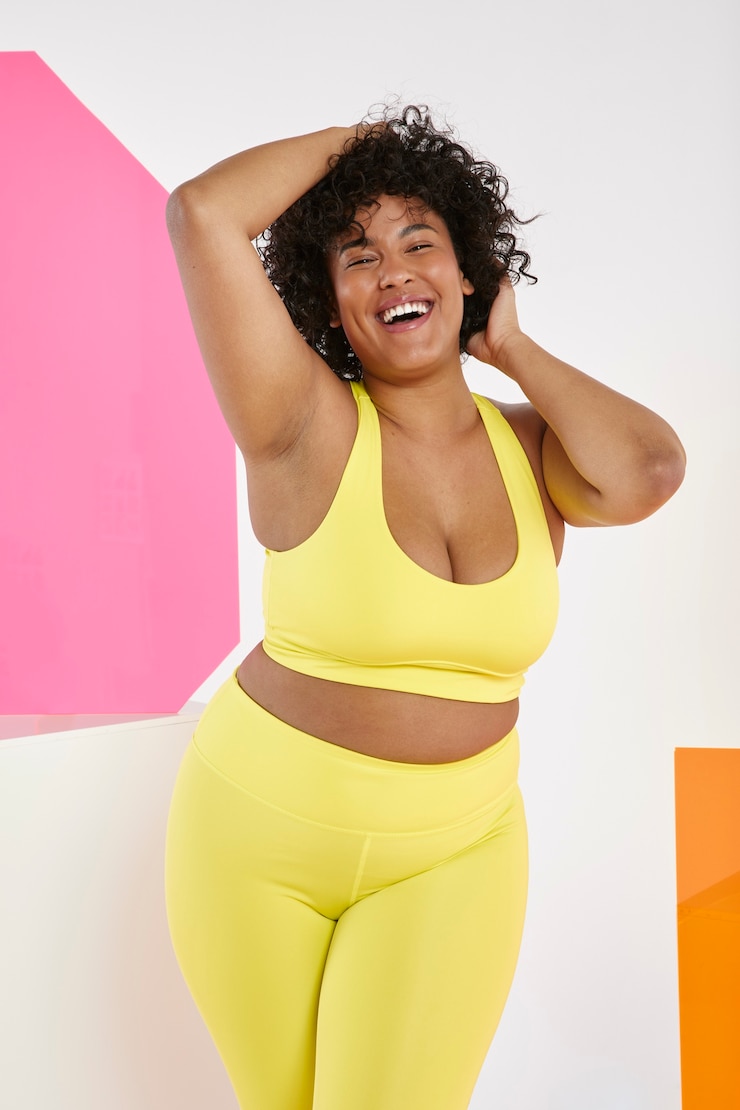 Foto gratuito donna del colpo medio che indossa un abito sportivo giallo