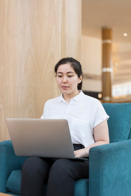 Donna del colpo medio che lavora al computer portatile