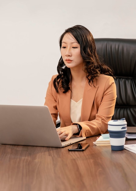 Donna del colpo medio che lavora al computer portatile