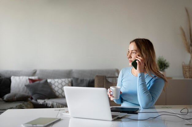 Donna del colpo medio che lavora al computer portatile