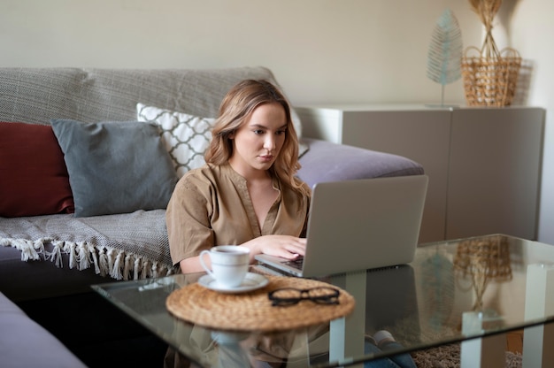 Donna del colpo medio che lavora al computer portatile