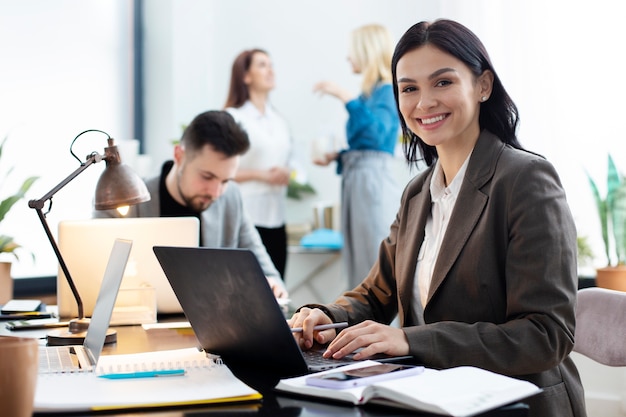 Donna del colpo medio che lavora al computer portatile