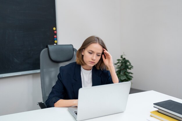 Donna del colpo medio che lavora al computer portatile