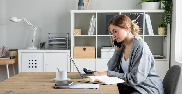 Donna del colpo medio che lavora con il computer portatile