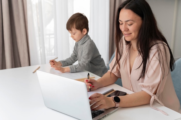 Donna del colpo medio che lavora con il computer portatile