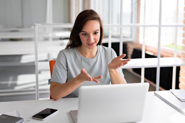 Donna del colpo medio che lavora con il computer portatile