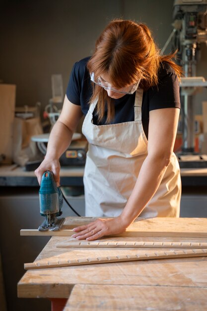 Donna del colpo medio che lavora in atelier