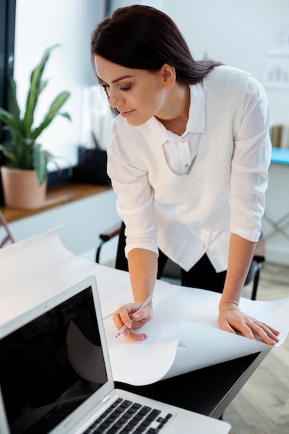 Donna del colpo medio che lavora in ufficio