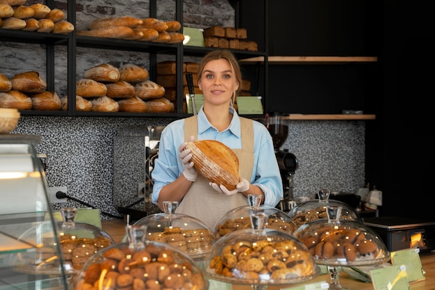 Donna del colpo medio che lavora nella panetteria