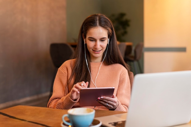 Donna del colpo medio che lavora sul tablet