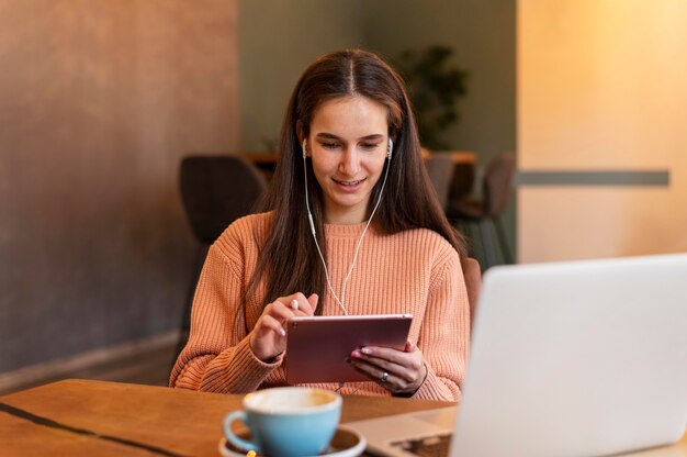 Donna del colpo medio che lavora sul tablet