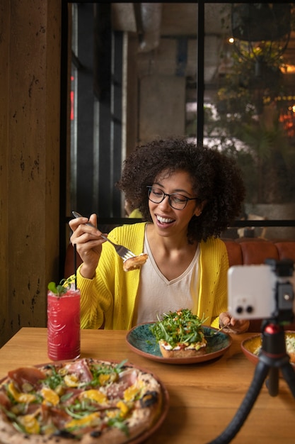 Donna del colpo medio che mangia cibo delizioso