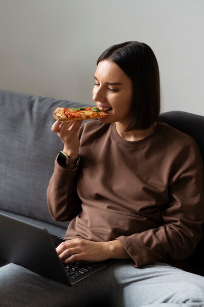 Donna del colpo medio che mangia pizza deliziosa