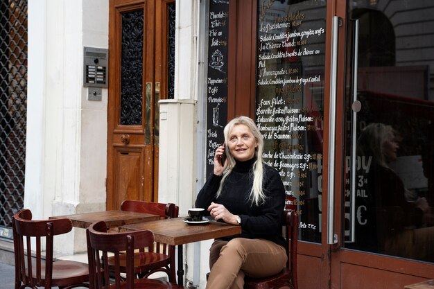 Donna del colpo medio che parla al telefono