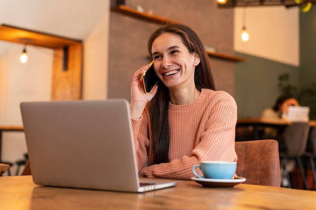 Donna del colpo medio che parla sul telefono