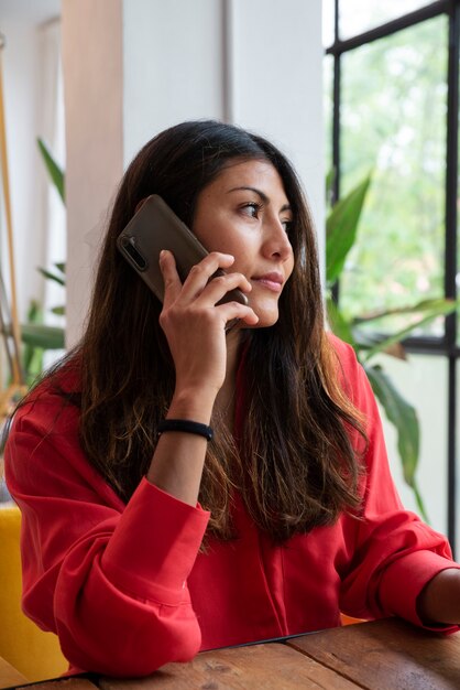 Donna del colpo medio che parla sul telefono