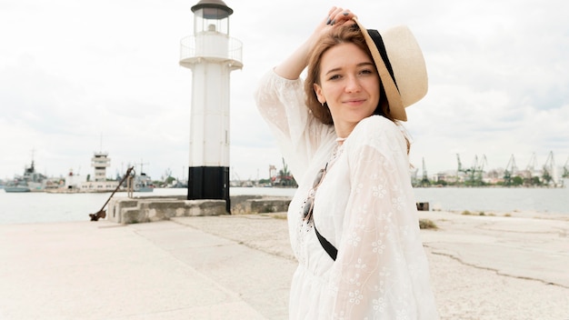 Donna del colpo medio che posa con il cappello