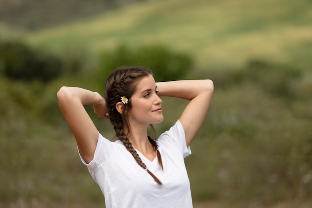 Donna del colpo medio che posa nella natura