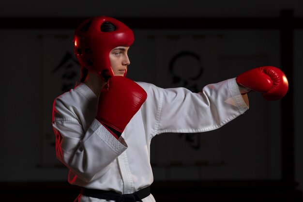 Donna del colpo medio che pratica taekwondo