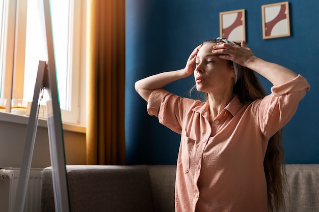 Donna del colpo medio che pratica yoga facciale