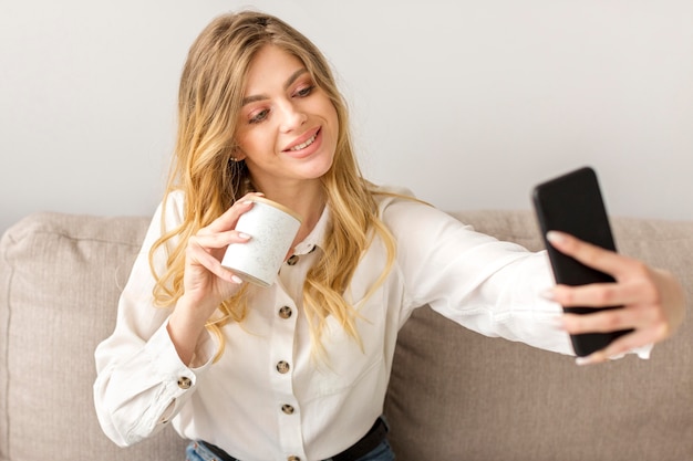 Donna del colpo medio che prende selfie