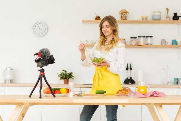 Donna del colpo medio che produce insalata