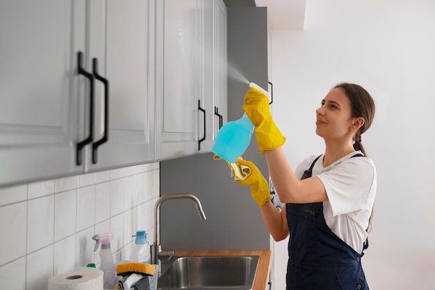 Donna del colpo medio che pulisce casa