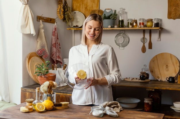 Donna del colpo medio che pulisce con il limone