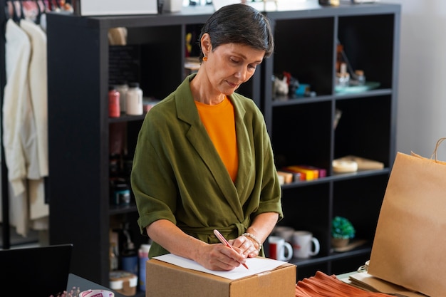 Donna del colpo medio che ripara articoli di moda