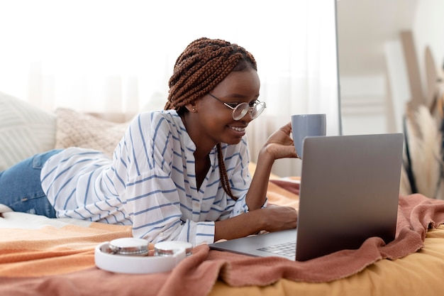 Donna del colpo medio che si rilassa con il computer portatile