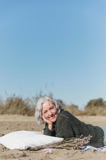 Donna del colpo medio che sorride all'aperto