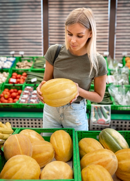 Donna del colpo medio che tiene melone