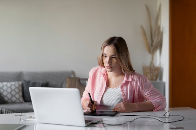 Donna del colpo medio che utilizza la tavoletta grafica